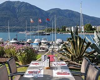 Tisch im Freien mit Blick auf den Hafen und die Berge.